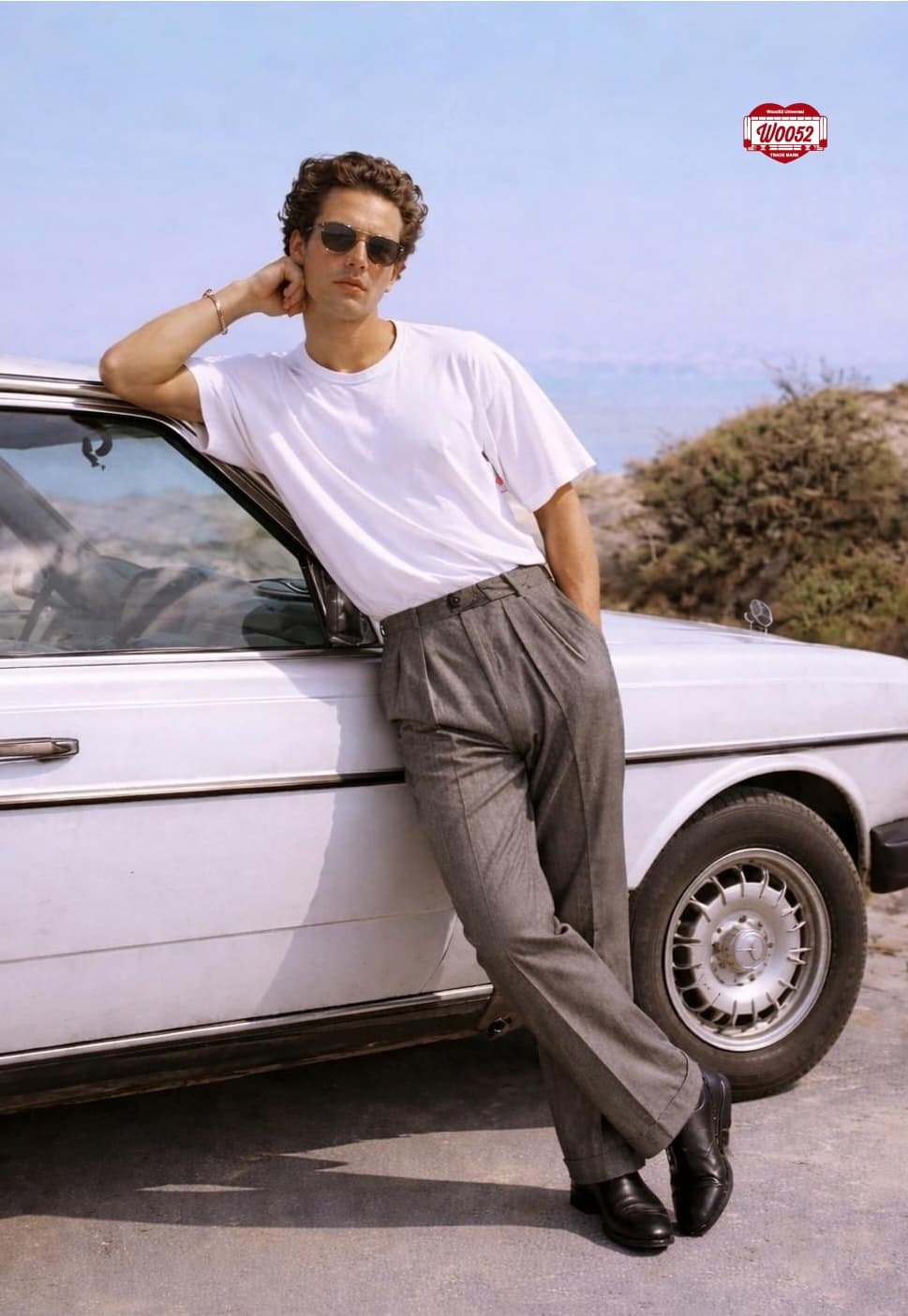 Modello appoggiato a un'auto bianca sulla costa, t-shirt bianca e pantaloni di flanella Woo52